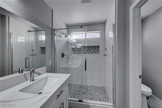 bathroom featuring walk in shower, vanity, and toilet