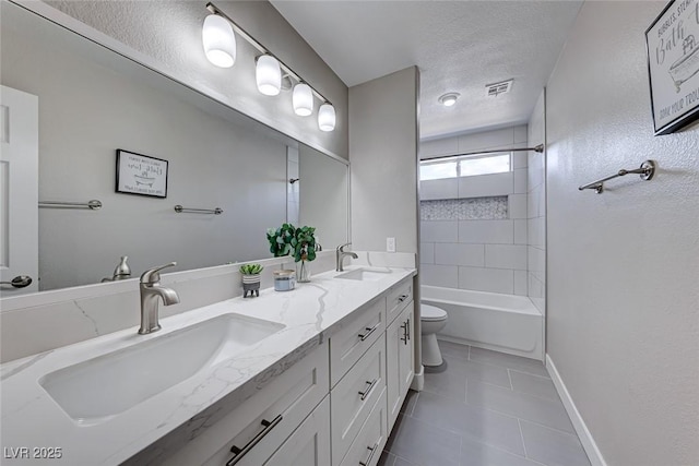 full bathroom featuring toilet, a textured ceiling, vanity, tiled shower / bath combo, and tile patterned flooring