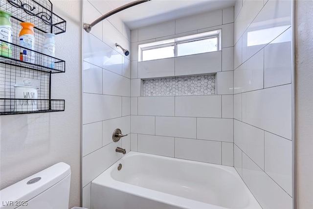 bathroom featuring tiled shower / bath and toilet