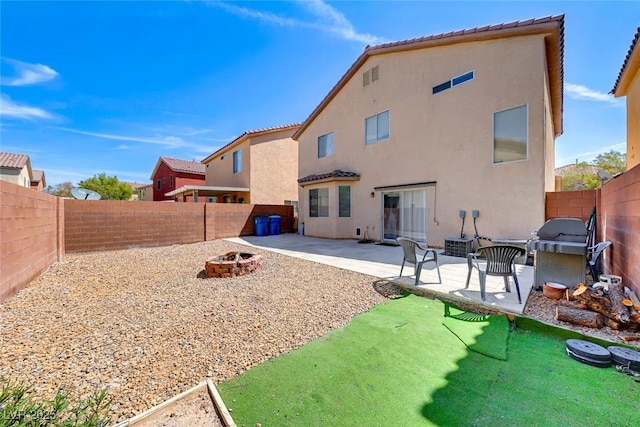 back of house with a fire pit and a patio