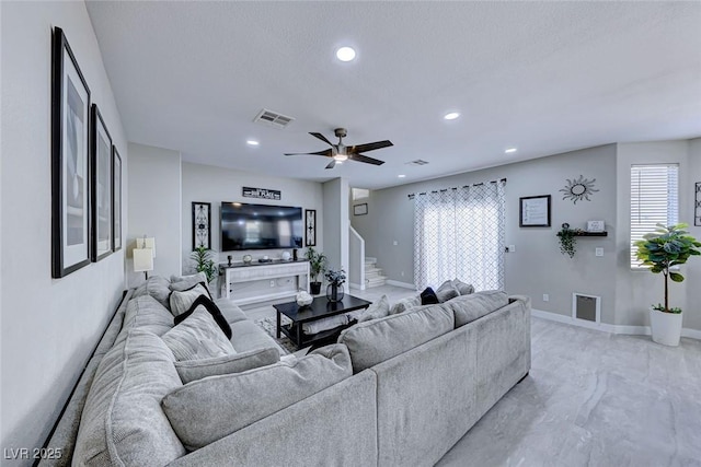 living room featuring a textured ceiling and ceiling fan