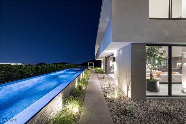 view of pool at twilight