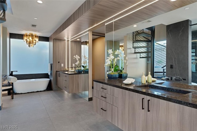 bathroom with vanity, a washtub, and tile patterned floors