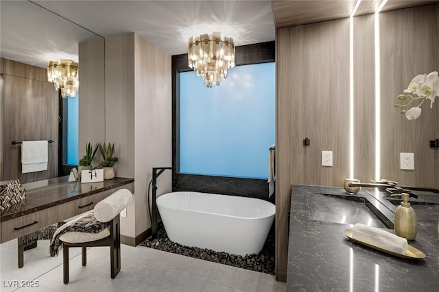 bathroom featuring tile patterned floors, sink, a chandelier, and a bathtub