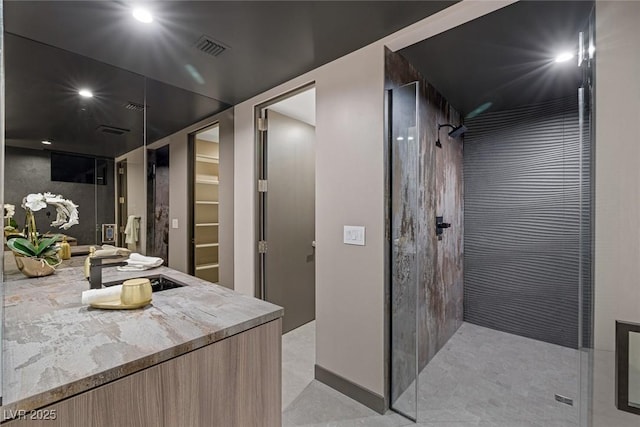 bathroom with sink and a tile shower