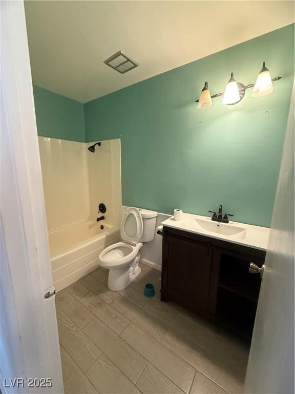 full bath with vanity, visible vents, wood finish floors, bathing tub / shower combination, and toilet