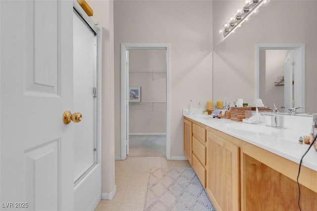 bathroom with tile patterned floors, vanity, and a shower with door