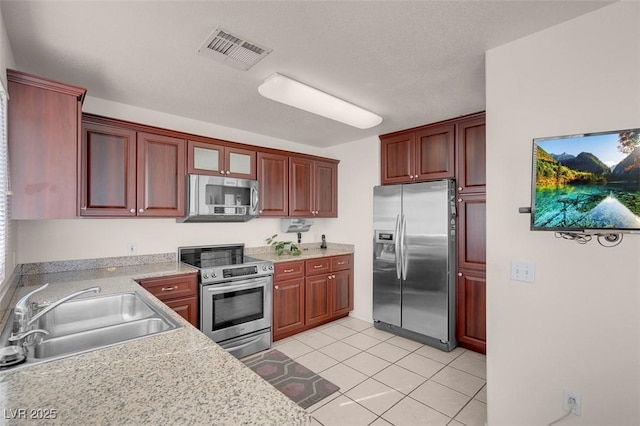 kitchen with sink, stainless steel appliances, and light tile patterned flooring