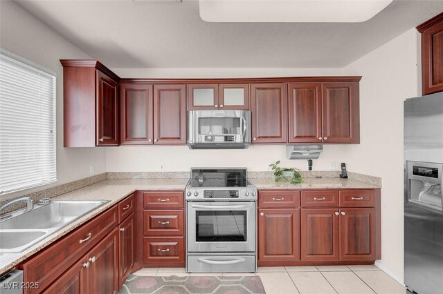 kitchen featuring stainless steel appliances, a healthy amount of sunlight, sink, and light tile patterned floors