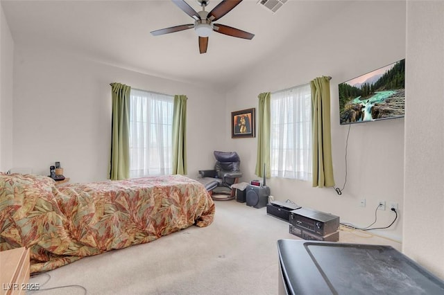 bedroom with multiple windows, vaulted ceiling, ceiling fan, and carpet flooring