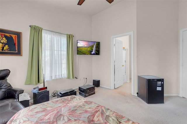 bedroom with ceiling fan, light carpet, and refrigerator