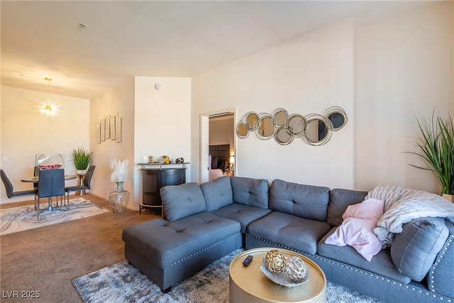 carpeted living room featuring a notable chandelier