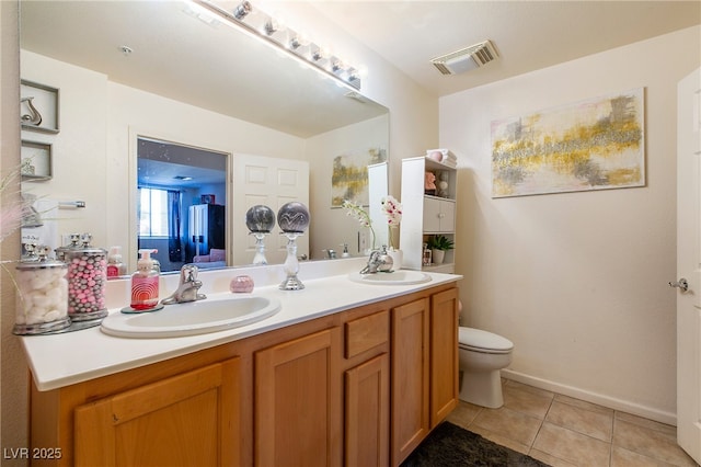 bathroom with vanity, tile patterned flooring, and toilet