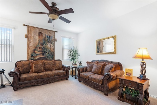 carpeted living area with a ceiling fan