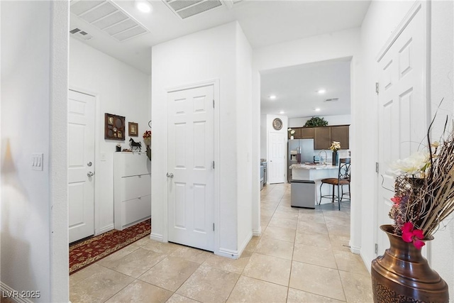 interior space featuring light tile patterned floors, baseboards, and visible vents