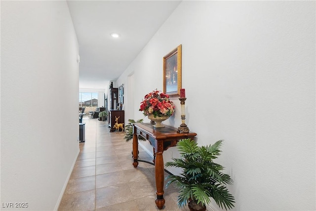 hall with light tile patterned flooring and baseboards