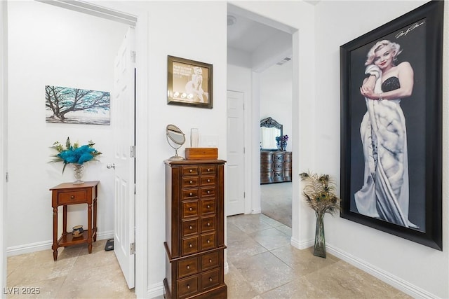 corridor featuring light tile patterned floors and baseboards