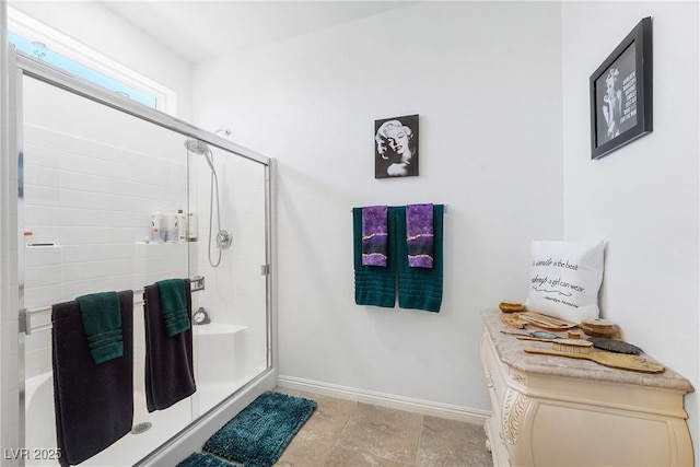 full bathroom featuring a stall shower and baseboards