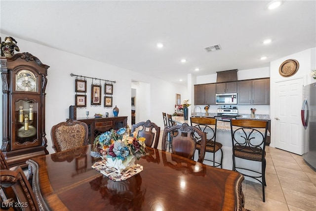 dining area with light tile patterned floors, visible vents, and recessed lighting