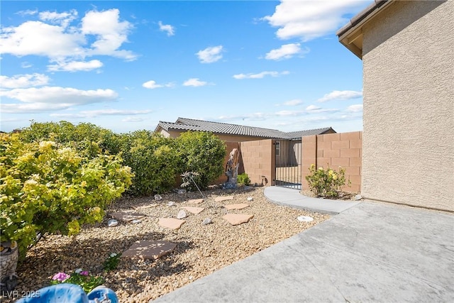 exterior space with concrete block siding, fence, and a gate