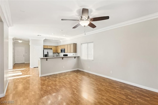 unfurnished living room with crown molding, ceiling fan, and light hardwood / wood-style flooring