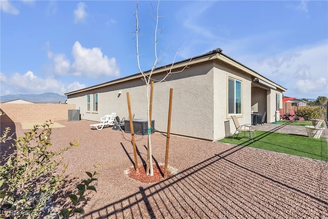 back of house featuring a patio, a mountain view, and central AC