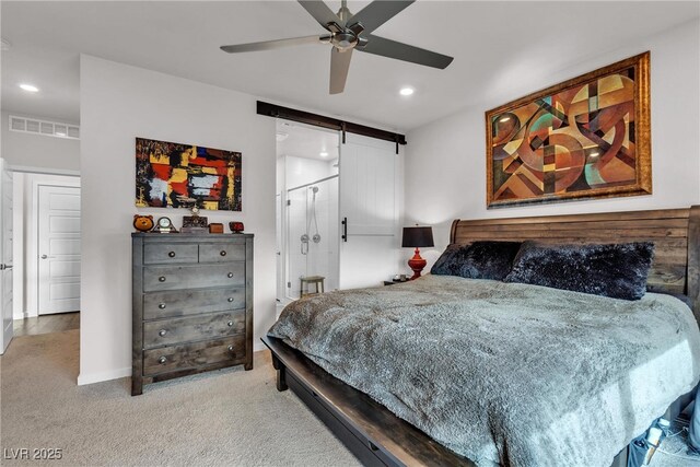 bedroom with a barn door, light carpet, and ceiling fan