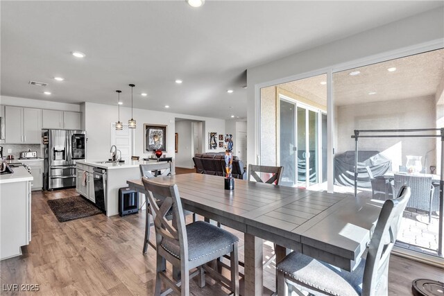 dining area with sink and light hardwood / wood-style flooring