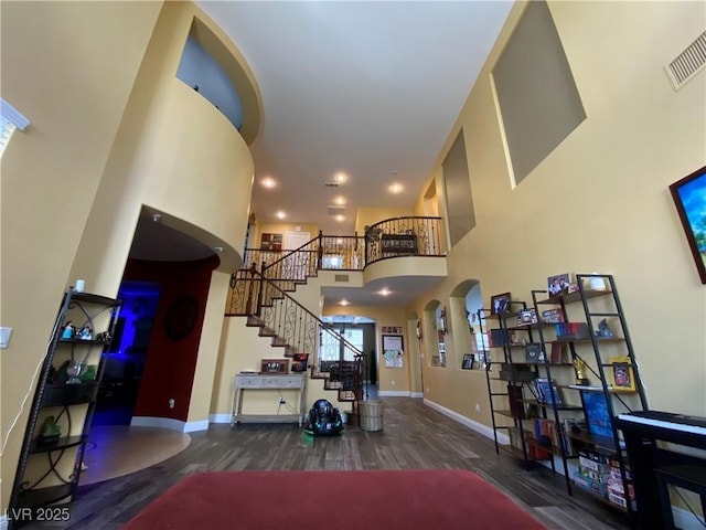 foyer entrance with wood-type flooring and a high ceiling