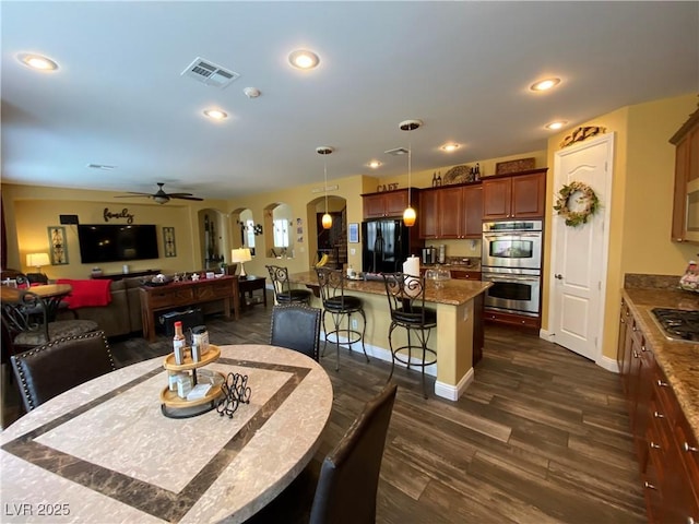 dining space featuring ceiling fan and dark hardwood / wood-style floors