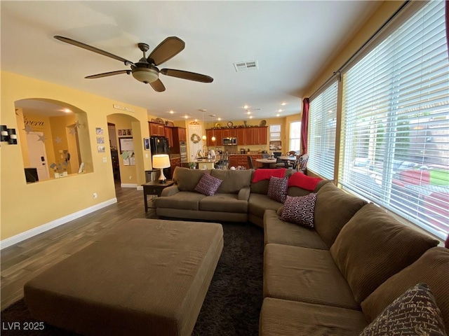 living room with dark wood-type flooring and ceiling fan