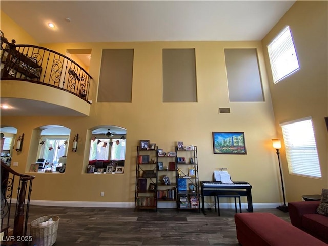 living room with dark hardwood / wood-style floors and a high ceiling