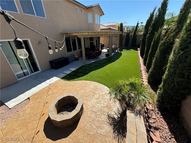 back of property featuring an outdoor fire pit, a pergola, a patio area, and a lawn