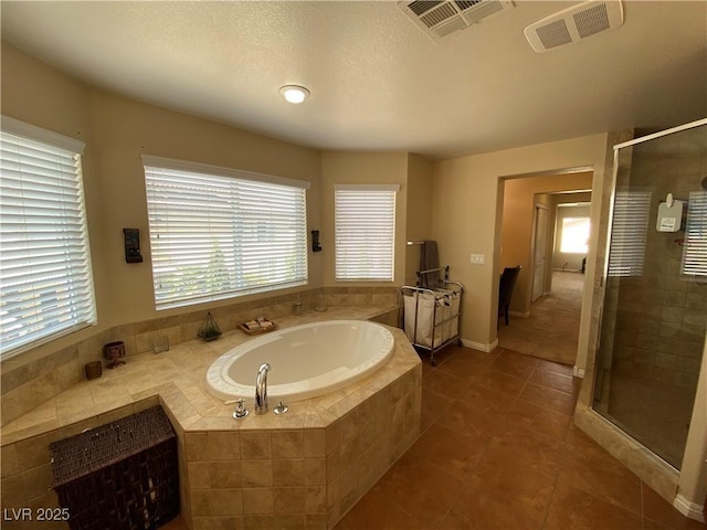 bathroom featuring tile patterned floors, shower with separate bathtub, and a textured ceiling