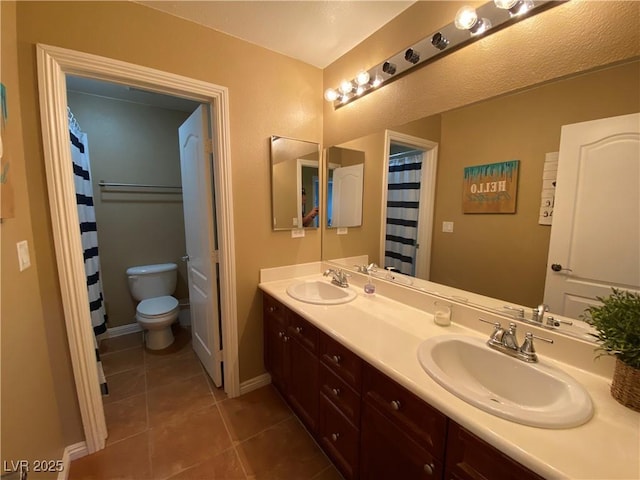 bathroom featuring vanity, toilet, and tile patterned flooring