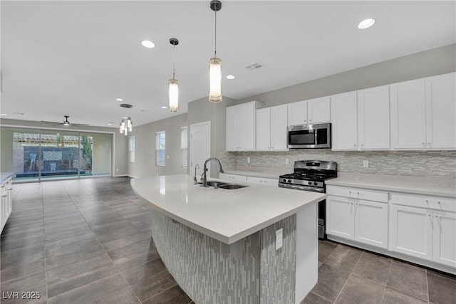 kitchen with visible vents, a sink, tasteful backsplash, stainless steel appliances, and light countertops