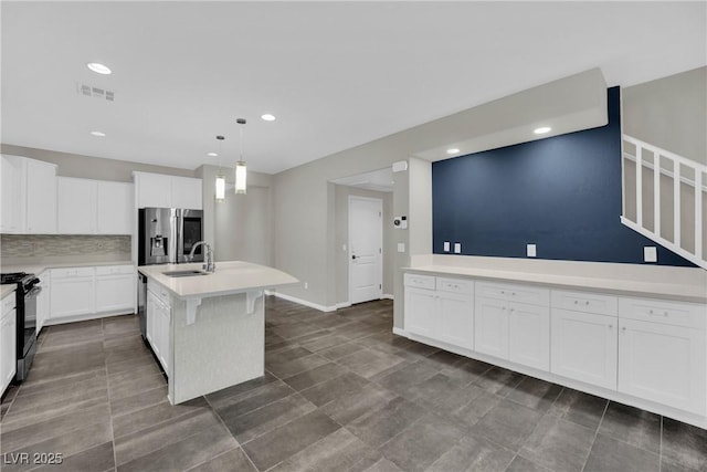 kitchen featuring white cabinets, a sink, visible vents, light countertops, and appliances with stainless steel finishes