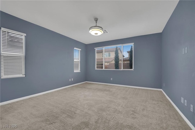 carpeted spare room with visible vents, baseboards, and a wealth of natural light