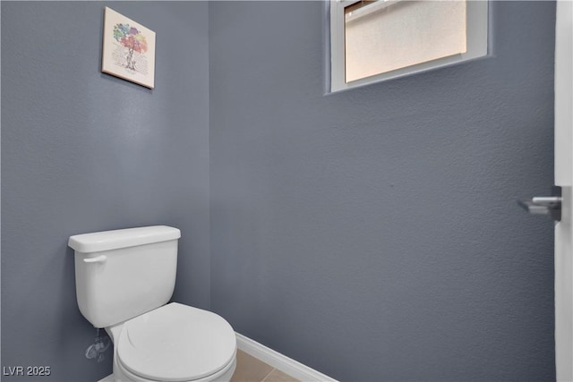 bathroom with baseboards and toilet