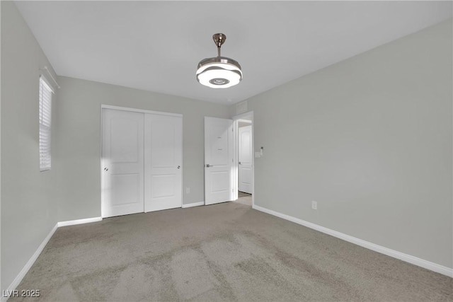 unfurnished bedroom featuring baseboards, carpet flooring, and a closet