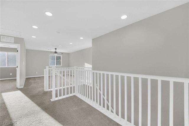 hall featuring baseboards, visible vents, recessed lighting, an upstairs landing, and carpet floors