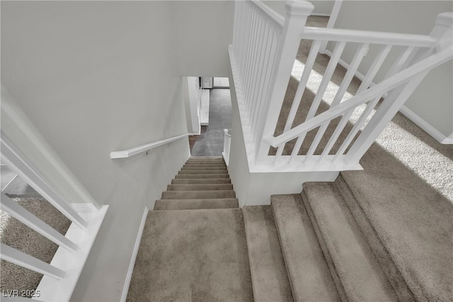 staircase with baseboards and carpet floors