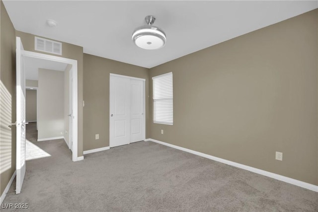 unfurnished bedroom featuring visible vents, baseboards, carpet, and a closet