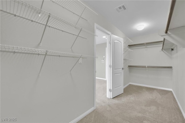 walk in closet featuring visible vents and carpet