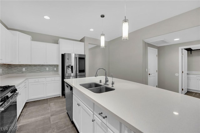 kitchen with white cabinets, a sink, light countertops, appliances with stainless steel finishes, and hanging light fixtures