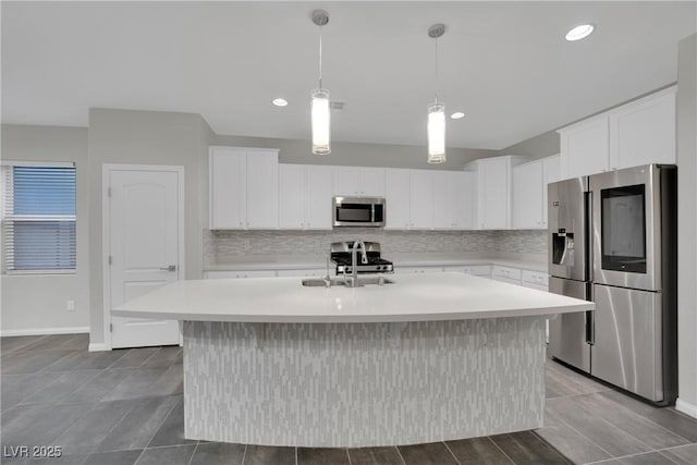 kitchen with light countertops, backsplash, appliances with stainless steel finishes, and a sink