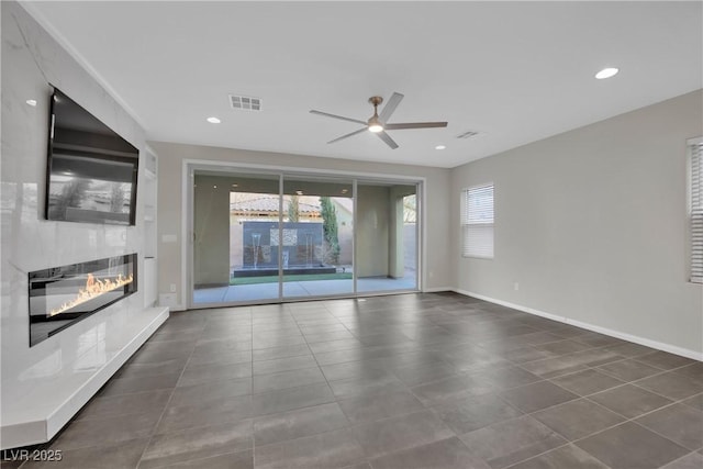 unfurnished living room featuring visible vents, recessed lighting, ceiling fan, and a glass covered fireplace