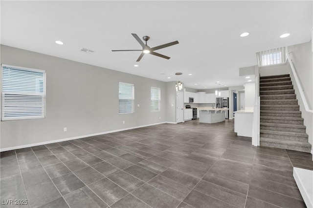 unfurnished living room featuring visible vents, recessed lighting, stairway, ceiling fan, and dark tile patterned floors