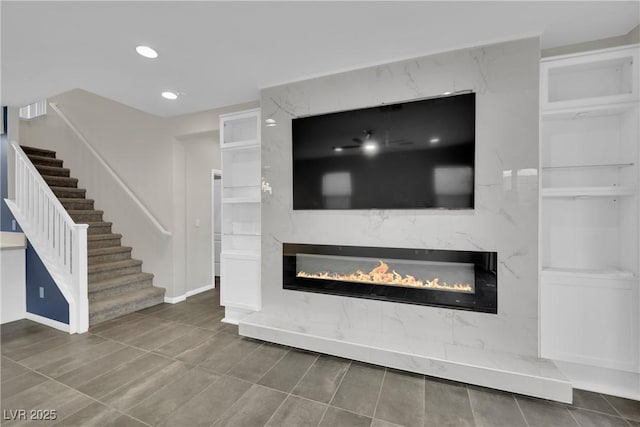 unfurnished living room featuring recessed lighting, stairs, and a premium fireplace