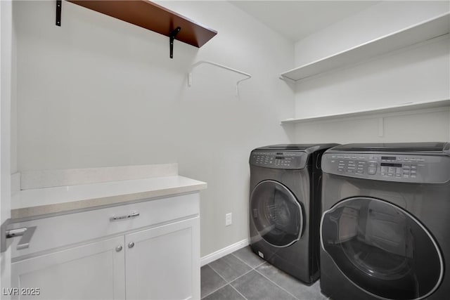 laundry area featuring light tile patterned floors, cabinet space, baseboards, and washing machine and clothes dryer